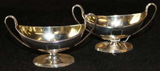 A pair of George III silver boat shaped two handled pedestal salts & a mustard pot.(-)